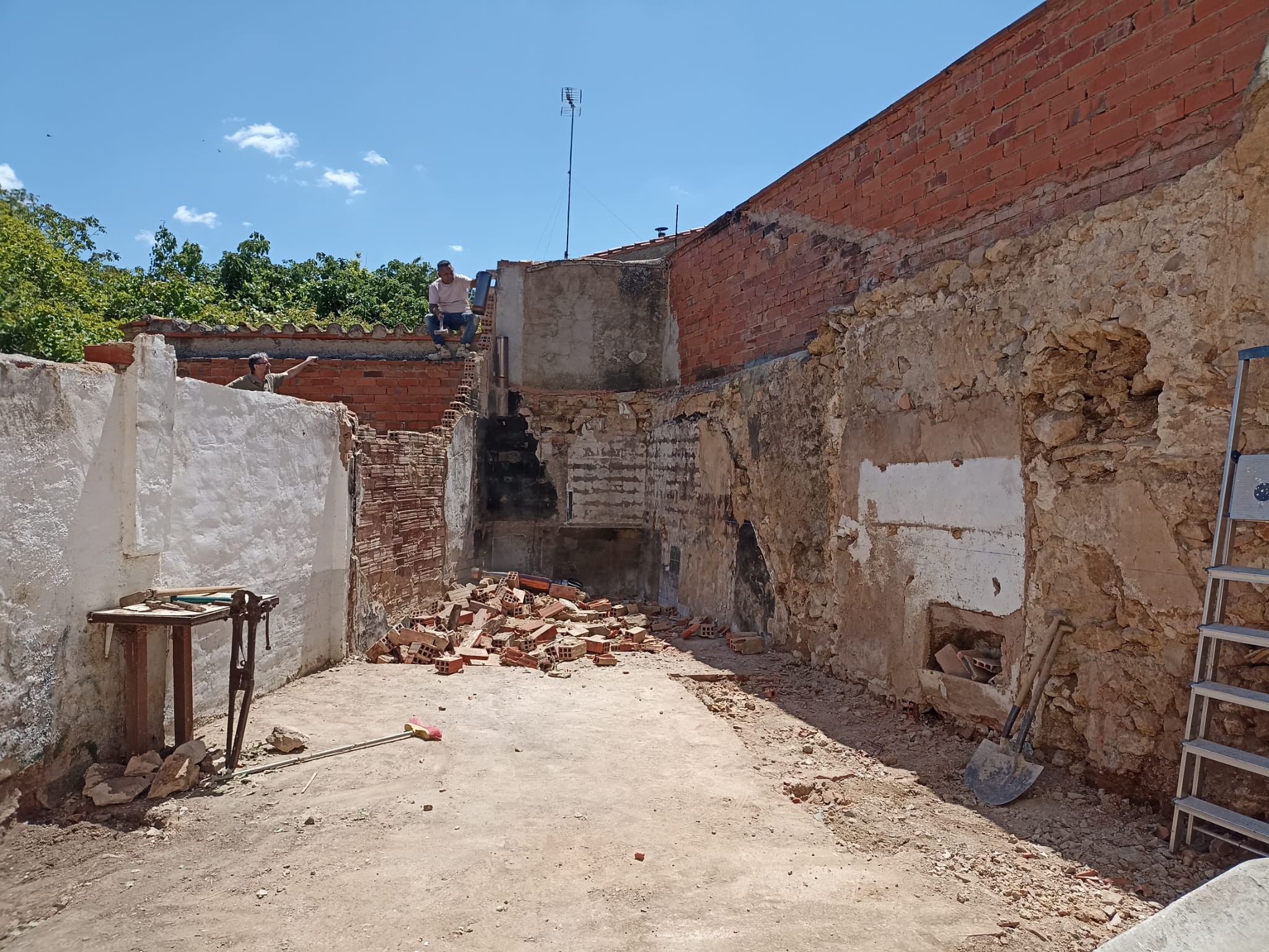 Demolición y escombros de muro y patio exterior antes de la reforma